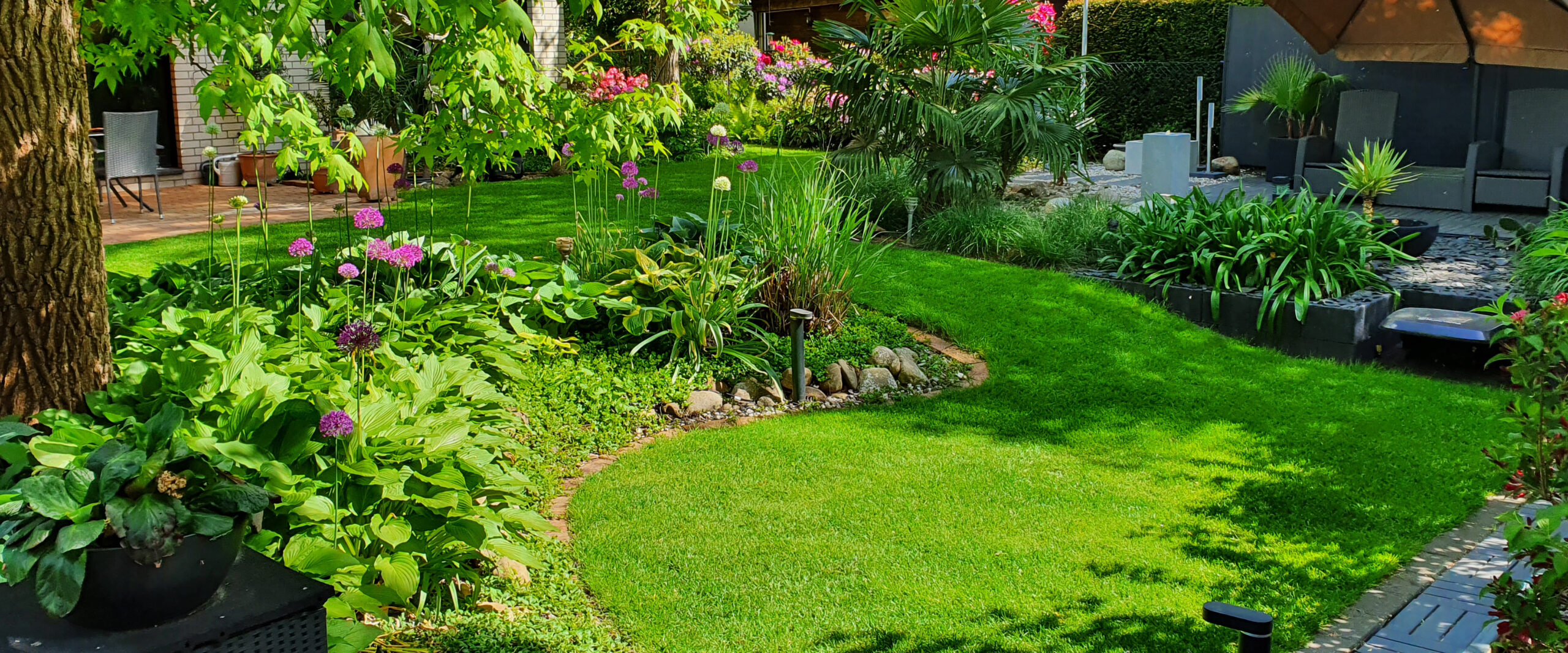 Mustergarten raindrop & garden mit Rasenfläche, Mähroboter und Gartenbeleuchtung